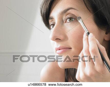 Stock Photo - Woman putting on make up. Fotosearch