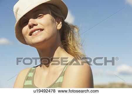 Stock Photo - Young woman wearing sun hat.. Fotosearch