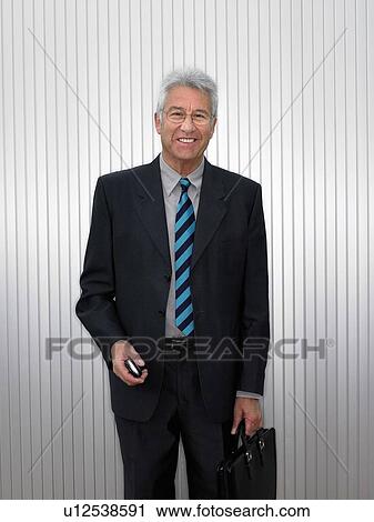 Stock Image - Businessman by a silver wall.. Fotosearch