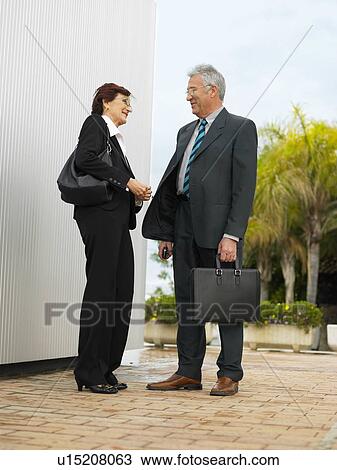 Businesspeople by a silver wall. View Large Photo Image Stock Image - Businesspeople by a silver wall.. Fotosearch