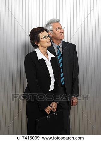 Stock Photo - Businesspeople by a silver wall.. Fotosearch
