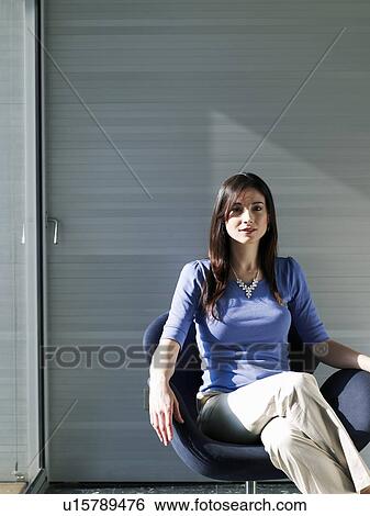 Businesswoman sitting in office, smiling, portrait View Large Photo Image Stock Photograph - Businesswoman sitting in office, smiling, portrait. Fotosearch