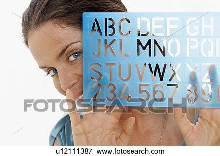 Stock Photo - Close-Up portrait of woman through window using graphic drawing equipment.. Fotosearch