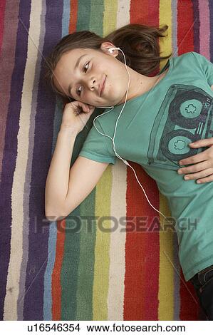Picture - Girl listening to music on mp3 player. Fotosearch