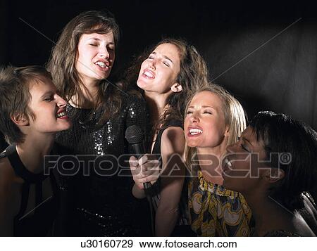 Stock Photo - Group of women singing, karaoke. Fotosearch