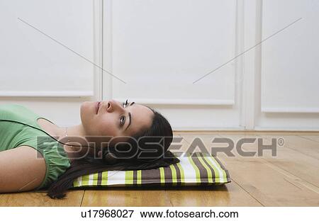 Woman lying on floor listening to music View Large Photo Image Stock Photo - Woman lying on floor listening to music . Fotosearch
