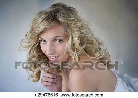 Stock Photograph - Young woman playing with her hair. Fotosearch