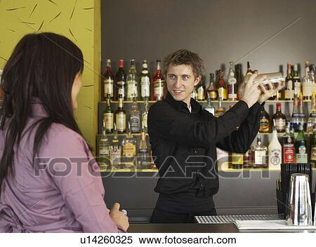 Young woman talking to barman View Large Photo Image Stock Photography - Young woman talking to barman. Fotosearch