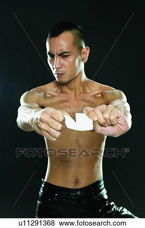Stock Photo - Torn, Asian Ethnicity, Semi-Dress, Breaking, Black Background, Placard. Fotosearch