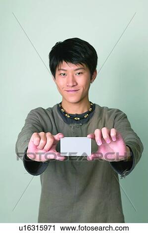 Stock Image - Young Adult, Close-Up, Holding, Confidence, One Person, One Young Man Only, Waist-Up. Fotosearch