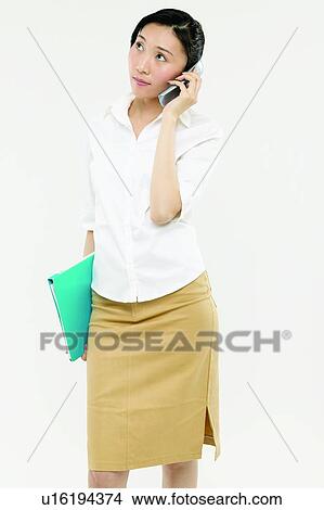 Picture - Black Hair, Wireless Technology, Talking, On The Phone, Listening, Three-Quarter Length, Connection. Fotosearch