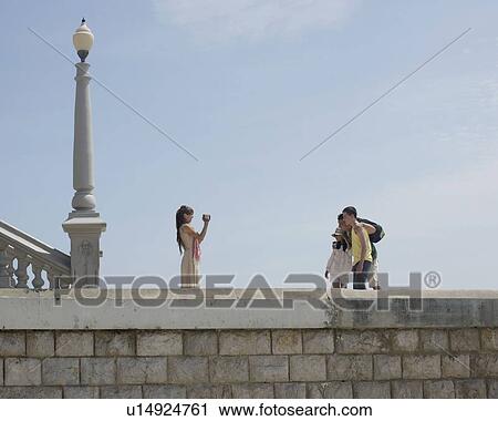Stock Image - Family taking video by sea. Fotosearch