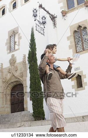 Picture - Father carrying son looking at map. Fotosearch