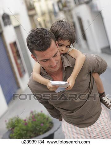 Father carrying son looking at map View Large Photo Image Picture - Father carrying son looking at map. Fotosearch