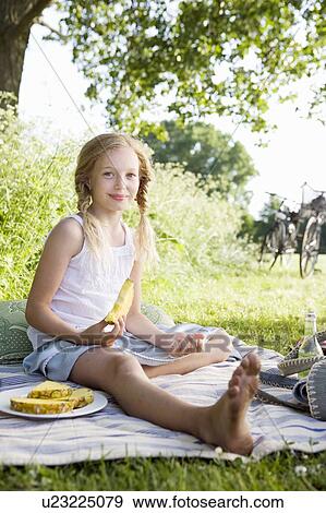 Stock Photo - Girl eating pineapple. Fotosearch