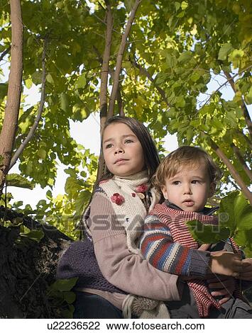 Girl holding boy in a tree. View Large Photo Image Stock Image - Girl holding boy in a tree.. Fotosearch