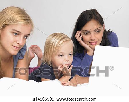 Stock Photography - Girls looking at a laptop. Fotosearch