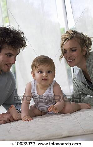 Parents watch baby, living carpet floor View Large Photo Image Stock Image - Parents watch baby, living carpet floor. Fotosearch
