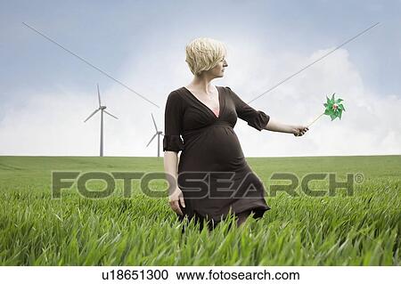 Stock Image - Pregnant woman playing with windmill. Fotosearch