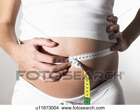 Picture - Pregnant woman taking her measurements. Fotosearch
