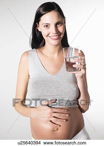 Picture - Pregnant woman with a glass of water. Fotosearch