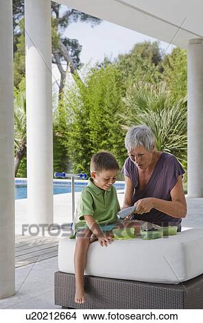 Picture - Woman and boy peeling fruit.. Fotosearch