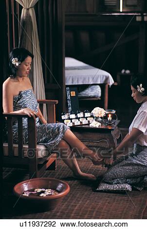 Stock Image - Barefoot, Chair, Casual Clothing, Black Hair, Asian Ethnicity. Fotosearch