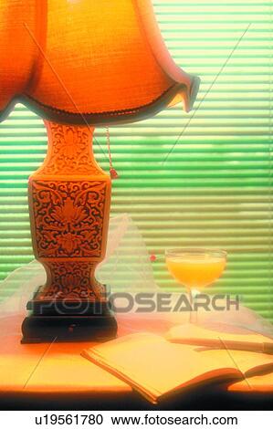 Stock Image - book, table lamp, scenery, venetian blind, drink, wineglass, foreign. Fotosearch