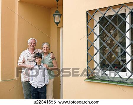 Boy (8-10) standing with grandparents on front porch, smiling, portrait View Large Photo Image Stock Photography - Boy (8-10) standing with grandparents on front porch, smiling, portrait. Fotosearch