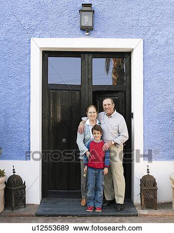 Grandparents and grandson (6-8) standing at front door, portrait View Large Photo Image Stock Photo - Grandparents and grandson (6-8) standing at front door, portrait. Fotosearch
