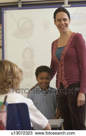 Teacher supporting student in classroom View Large Photo Image Stock Image - Teacher supporting student in classroom. Fotosearch