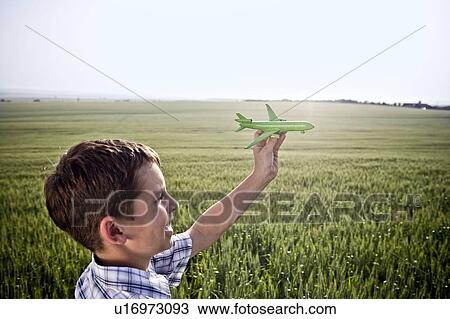 Stock Image - Boy playing with toy plane. Fotosearch