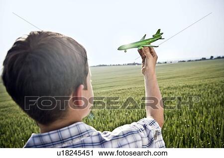 Stock Image - Boy playing with toy plane. Fotosearch