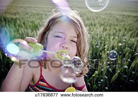 Girl blowing bubbles to camera View Large Photo Image Stock Photo - Girl blowing bubbles to camera. Fotosearch