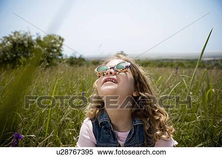 Stock Photography - Girl looking up at sun. Fotosearch
