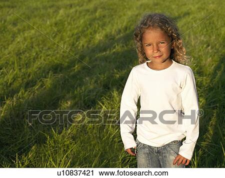 Little girl standing in a field. View Large Photo Image Stock Image - Little girl standing in a field.. Fotosearch