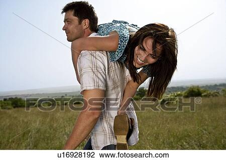 Stock Image - Man carrying woman. Fotosearch