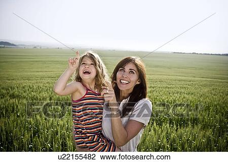 Stock Image - Woman and child pointing at sky. Fotosearch