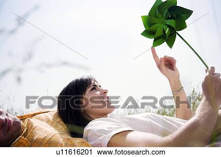Stock Image - Woman in grass with windmill. Fotosearch