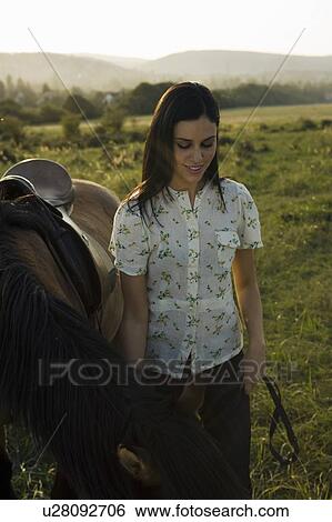Stock Photograph - Woman standing with horse.. Fotosearch