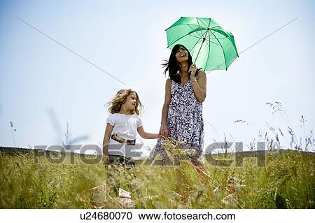 Woman with daughter holding umbrella View Large Photo Image Stock Image - Woman with daughter holding umbrella . Fotosearch