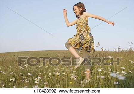 Young girl skips in meadow View Large Photo Image Stock Image - Young girl skips in meadow. Fotosearch