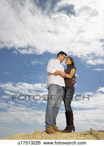 Stock Photograph - Couple embracing on hilltop, Alicante, Spain,. Fotosearch