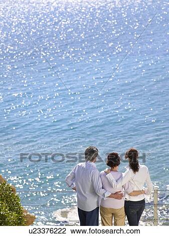 Stock Image - Family looking out to sea. Fotosearch