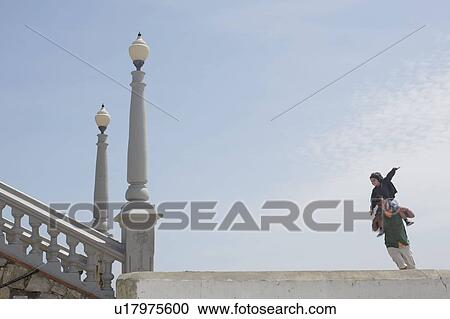 Father carrying son on shoulders View Large Photo Image Stock Image - Father carrying son on shoulders. Fotosearch