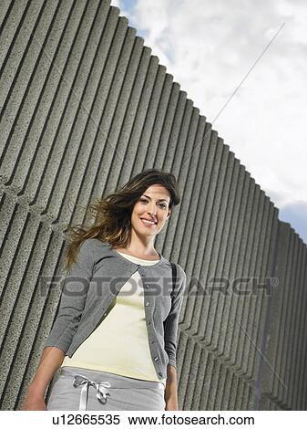 Low angle portrait of young woman by textured concrete wall, Alicante, Spain, View Large Photo Image Stock Photography - Low angle portrait of young woman by textured concrete wall, Alicante, Spain,. Fotosearch