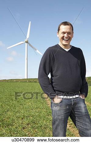 Stock Photo - Man smiling on a wind farm. Fotosearch