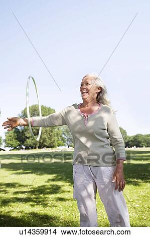 Picture - Mature woman with hula-hoop. Fotosearch