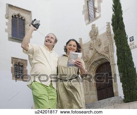Stock Photo - Retirees taking video and looking at map. Fotosearch