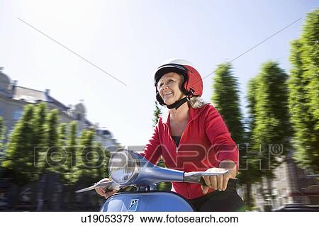 Stock Photo - Woman driving a scooter. Fotosearch